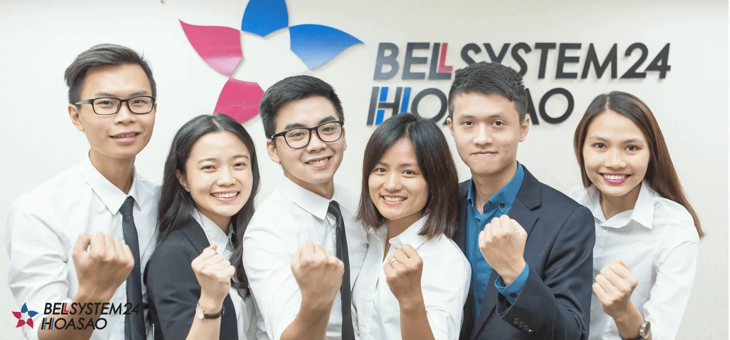 Six smiling Bellsystem24 Hoa Sao team members in front of the company logo