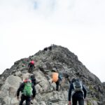 climbers hiking through mountain peak during daytime